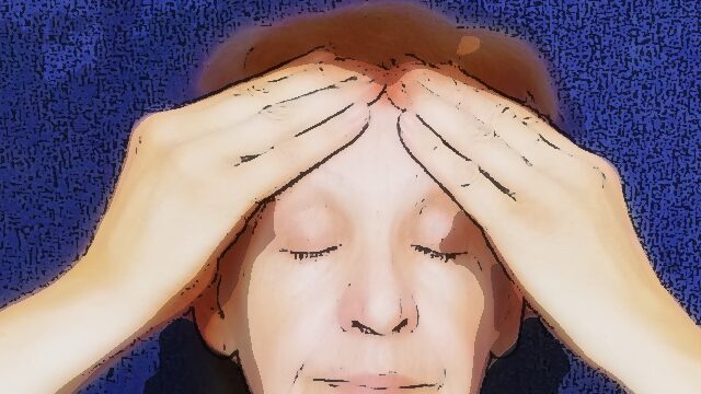 woman massages her forehead with both hands Self facial massage: a woman massages her forehead with both hands.